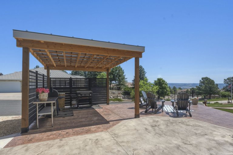 Modern wooden pergola with shade structure over patio seating area in residential outdoor space