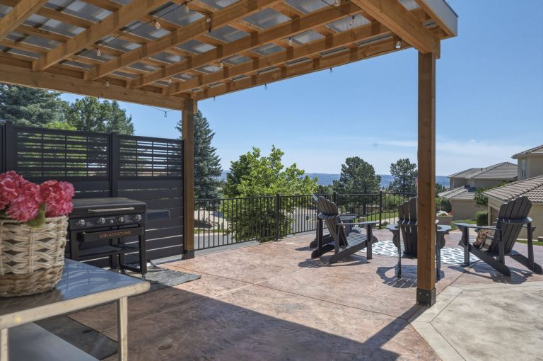 Modern wooden pergola with lattice shade structure over patio seating area with mountain views