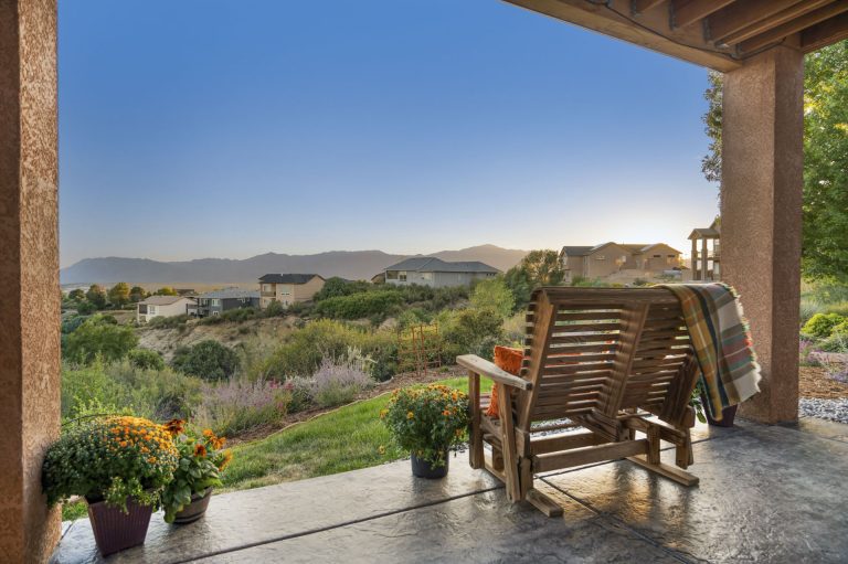 Tuscan villa terrace with wooden chairs overlooking rolling hills and countryside landscape