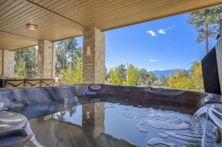 Indoor hot spring bath with mountain views through large windows and wooden ceiling