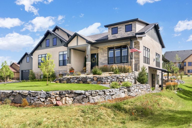 Modern two-story home with stone foundation and landscaping in residential neighborhood