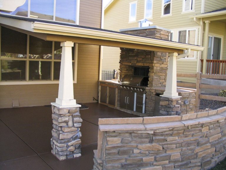 Covered patio with stone pillars and brick accents attached to a residential home